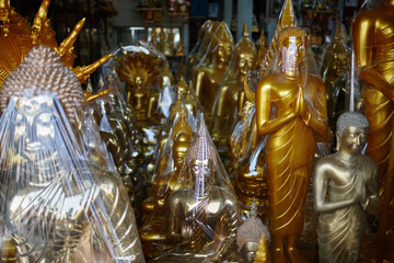 various religious gold and bronze figurines in a souvenir shop
