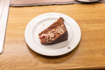 Chocolate cake on its side on a white plate.