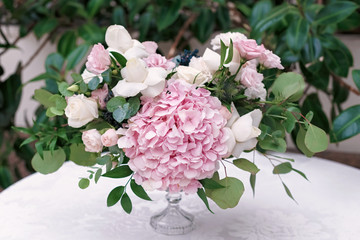 Original wedding floristics closeup. The wedding flower bouquet is supplemented with rose hortensia, roses and greenery. Floral background