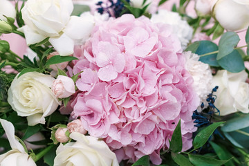 Original wedding floristics closeup. The wedding flower bouquet is supplemented with rose hortensia, roses and greenery. Floral background