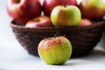 red and green apples in a basket close up