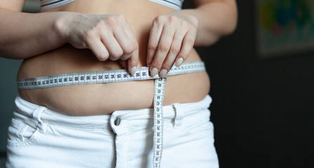 Fat female belly measures with tape, overweight body