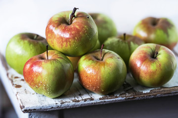 red and green apples on a wooden table close up on a light background