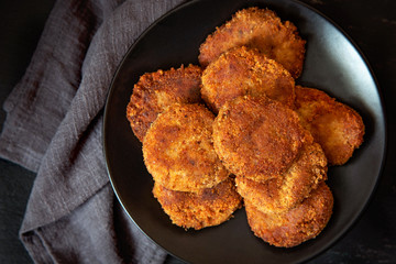 Juicy homemade cutlets on a black plate. Top view