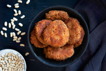 Vegetarian bean patties or cutlets on a black plate. Top view