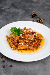 Cooked chicken fillet with pine nuts in a white plate
