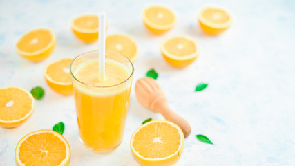 Orange juice in glass, fresh fruits on wooden background