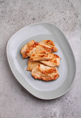 Fried chicken with soy sauce on a plate, top view