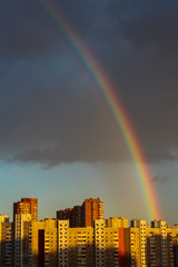 Rainbow over the roofs of houses after rain in the city.