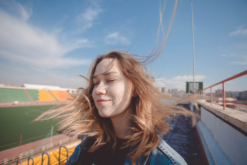 A girl stands on the top rows of a football stadium