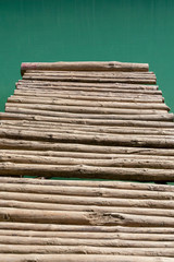 wooden bridge of bars on the lake close-up