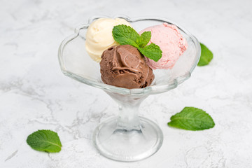 Three balls of ice cream in a transparent glass