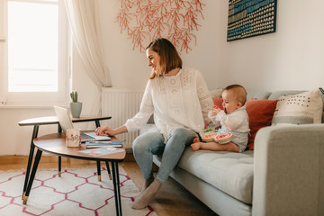 young business mother works from home with her cute baby