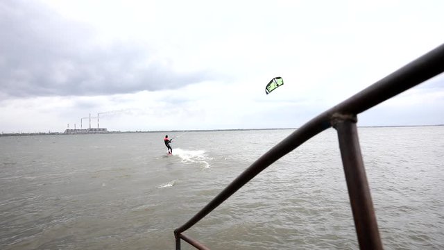 A man rides a kite on a lake