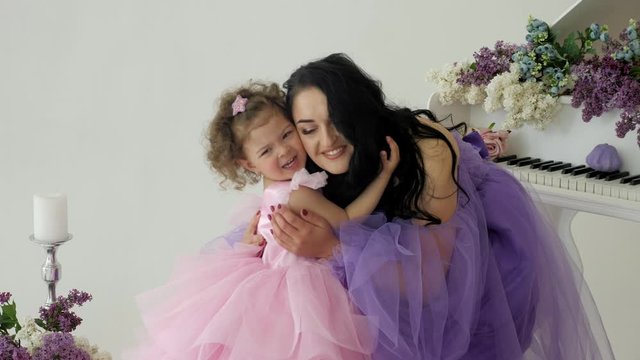happy mother smiling and hugging her little daughter