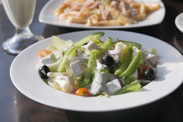 Fresh greek salad with feta cheese, tomato, lettuce, black olives and onion.