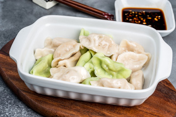 Lamb dumplings in a deep white plate on a gray background