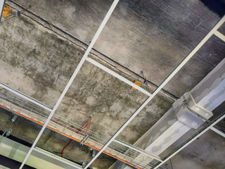 Open plenum of suspended ceiling with tiles removed from t-bar grid to show cable tray and ducting
