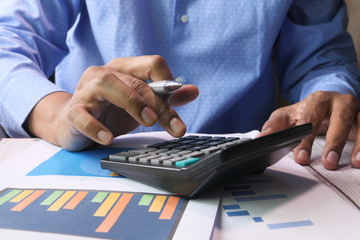 person hand using calculator on offie desk.