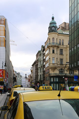 Bright yellow taxi cabs on a city street in evening Prague