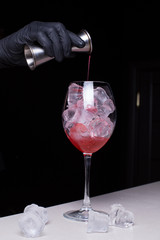 Making a berry summer cocktail with red liquor