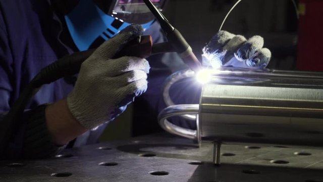 Industrial worker cutting and welding metal