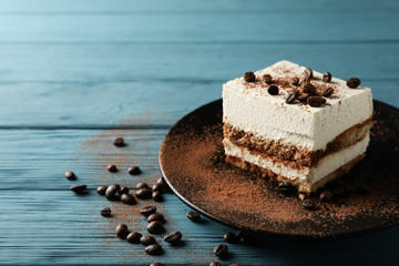 Plate with tiramisu on wooden background. Tasty dessert