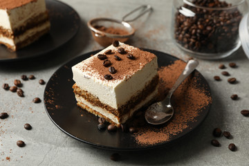 Composition with tasty tiramisu and coffee beans on gray background