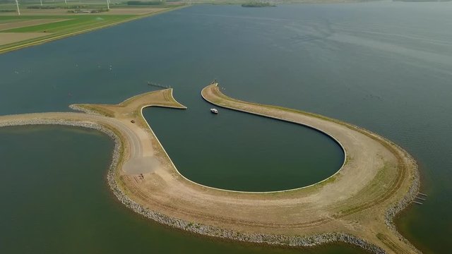 Aerial drone shot over the man made Peninsula Tulip island at the coastline of the Zeewolde, Netherlands.