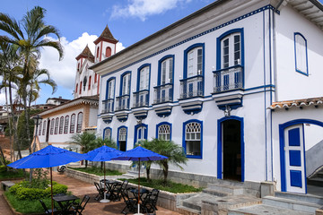 Fototapeta na wymiar View to beautiful historic building and church, with palm trees and blue sky with white clouds, Serro, Minas Gerais, Brazil