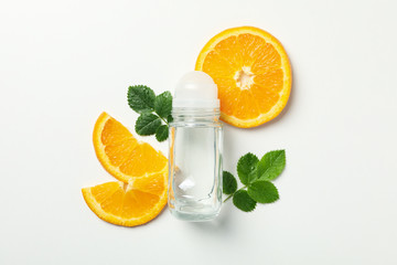 Body deodorant roll-on, leaves and citrus on white background