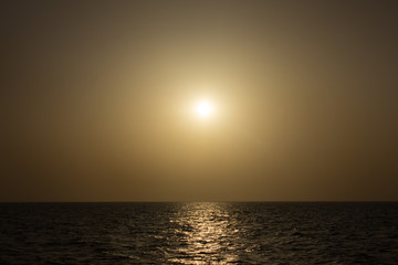 Fototapeta na wymiar Fog in the sea during the dawn. Orange sky and water.