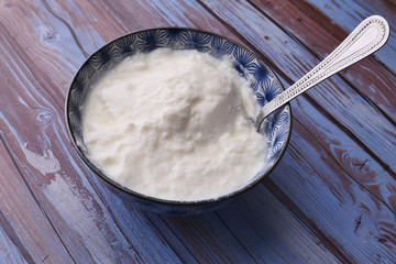 close up of fresh yogurt in a bowl on color background 