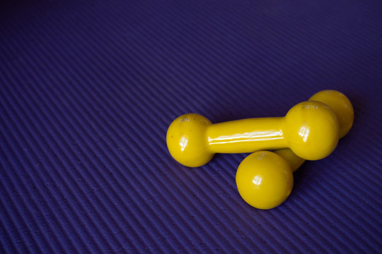 Yellow Dumbbells On A Violet Background