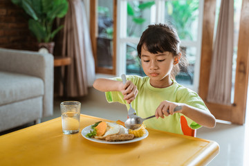 independent kid self eating at home having some breakfast