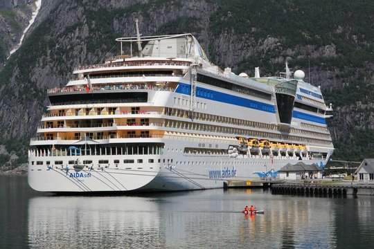 EIDFJORD, NORWAY - JULY 17, 2015: People enjoy their AIDAsol cruise in Norway. AIDA sol was built by Meier Werft in 2011. It can carry 2,174 passengers.