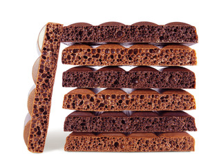 Stack of dark and milk porous chocolate pieces isolated on white background  