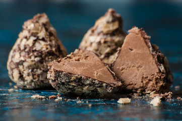 Delicious chocolate candies in waffle crumbs cut in half closeup macro, side view