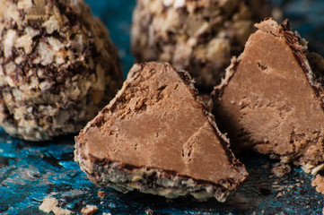 Delicious chocolate candies in waffle crumbs cut in half closeup macro, side view