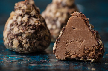 Delicious chocolate candies in waffle crumbs cut in half closeup macro, side view