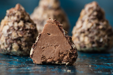 Delicious chocolates in waffle crumbs cut in half closeup macro, side view and copy space