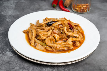 Braised meat with vegetables served in a white round plate