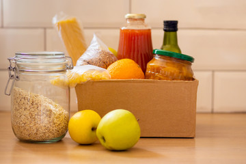 Humanitarian assistance during the coronavirus pandemic. Box with essentials, pasta, cereals and fruits.