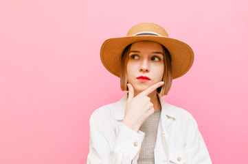 Pensive attractive girl in summer clothes and hat looks away at copy space and thinks. Lady tourist...