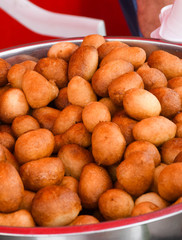 Fresh round small donuts during carnival or fast food festival, glazed with dark and white chocolate