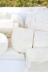 A variety of wheels of cheese seasoned with herbs for sale at the deli counter in the supermarket.