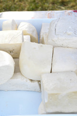 A variety of wheels of cheese seasoned with herbs for sale at the deli counter in the supermarket.