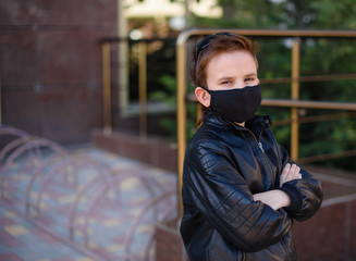 Boy in black mask folds his hands and looks to the camera. Looking upset about coronavirus