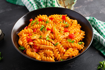 Fusilli pasta with chicken and sweet pepper in tomato sauce. Italian Cuisine.