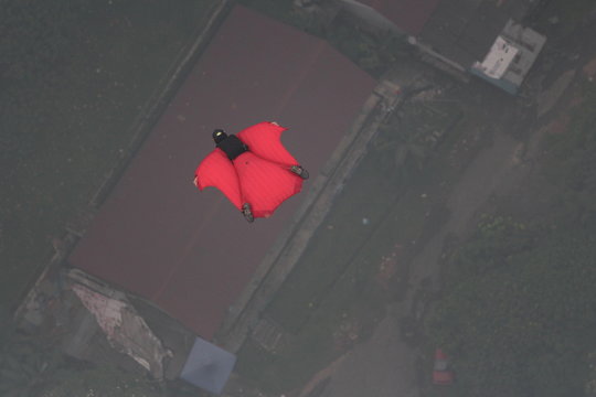 High Angle View Of Base Jumper Flying In Mid-air